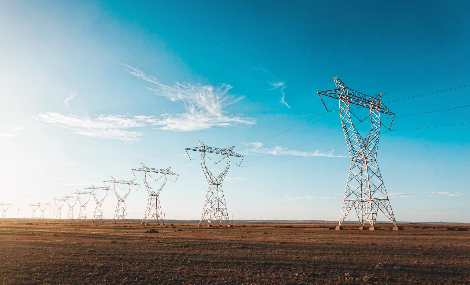 High-voltage transmission lines under a clear sky — power delivered by Lulian cable